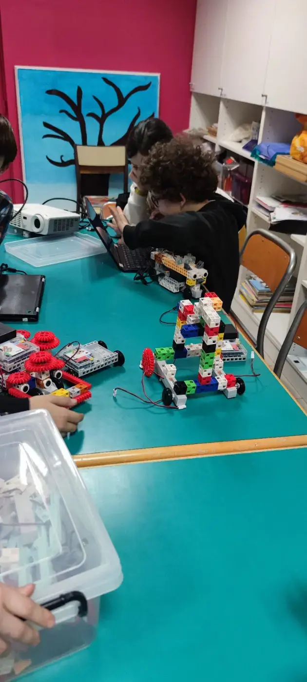 Plusieurs participants coopèrent autour de robots construits pendant un atelier ManLiBot.