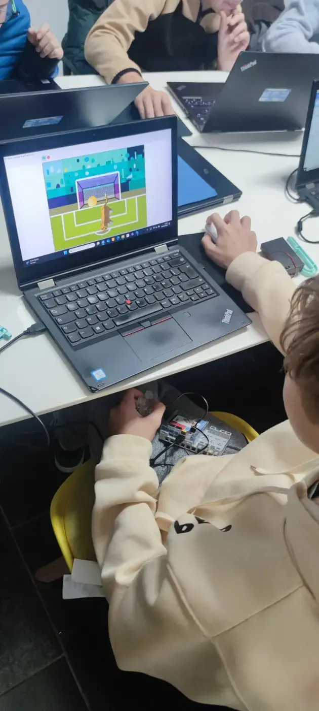 Un participant programme une animation et teste son montage robotique pendant un atelier.